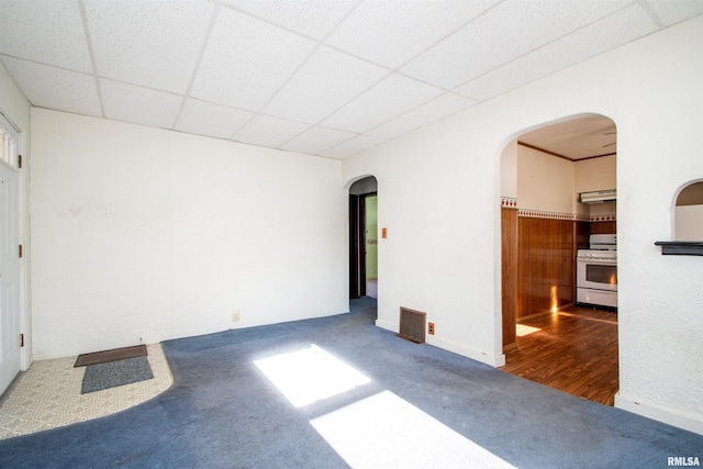 carpeted empty room featuring a drop ceiling