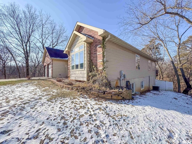 view of snowy exterior featuring central AC