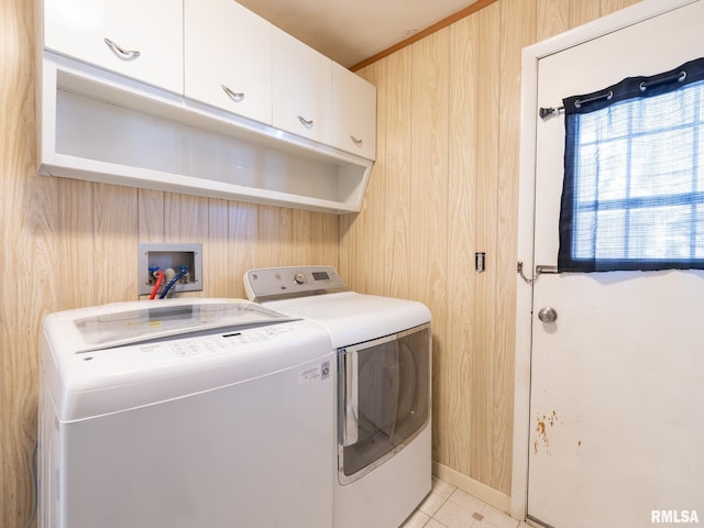 washroom featuring wood walls, light tile patterned floors, cabinets, and independent washer and dryer