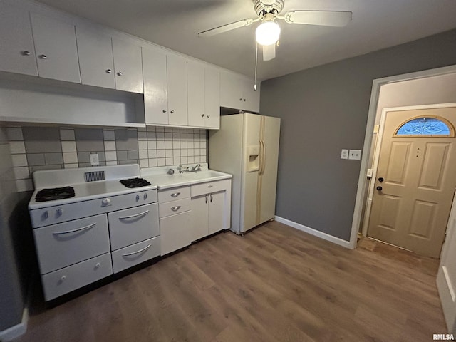 kitchen featuring white cabinets, backsplash, and white fridge with ice dispenser