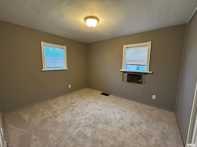 empty room with light carpet and a textured ceiling