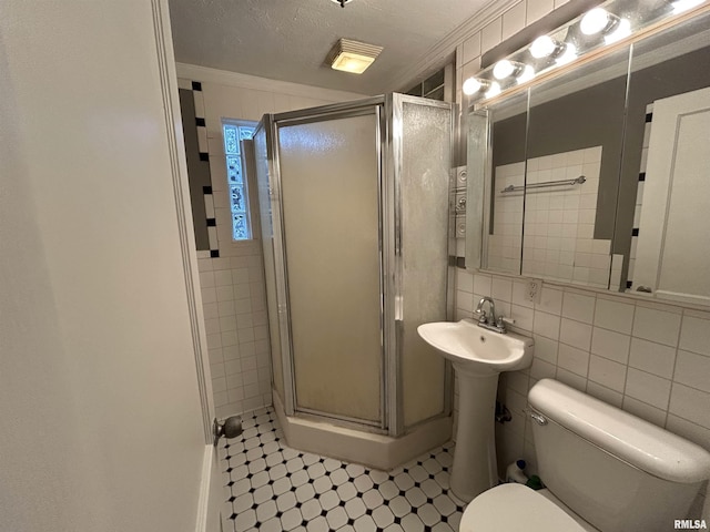 bathroom with backsplash, a shower with door, crown molding, tile walls, and toilet