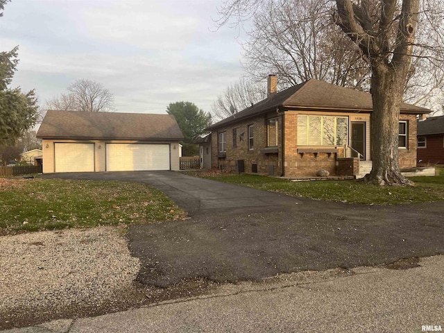 view of side of home featuring a garage, an outdoor structure, and a yard