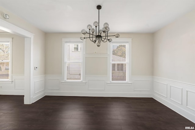 unfurnished dining area with an inviting chandelier and dark wood-type flooring