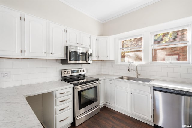 kitchen featuring sink, dark hardwood / wood-style floors, appliances with stainless steel finishes, tasteful backsplash, and white cabinetry