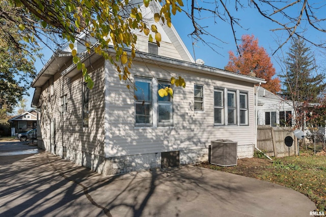 view of side of property featuring cooling unit and a patio