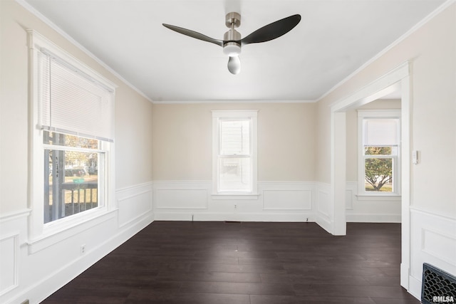 empty room with a wealth of natural light, dark wood-type flooring, and ornamental molding