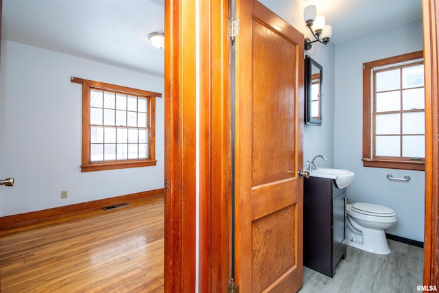 bathroom featuring hardwood / wood-style flooring, vanity, and toilet