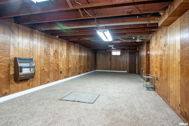 basement with carpet flooring, heating unit, and wooden walls