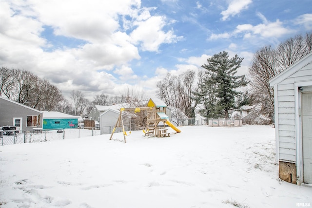 yard layered in snow with a playground