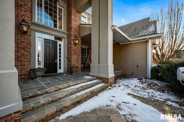 snow covered property entrance featuring covered porch