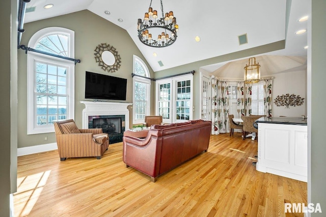 living room featuring vaulted ceiling, a wealth of natural light, and light hardwood / wood-style flooring