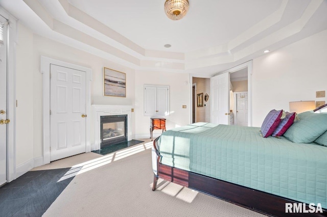 carpeted bedroom with a raised ceiling