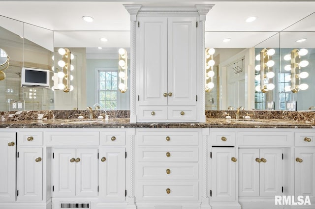 bathroom featuring vanity, an enclosed shower, and ornamental molding