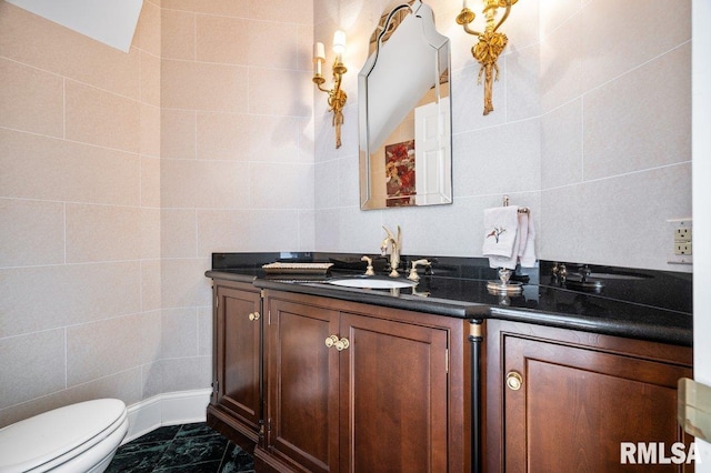 bathroom featuring vanity, toilet, and tile walls