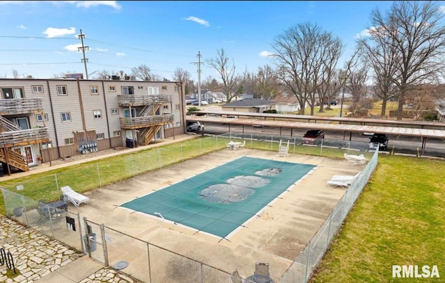 view of swimming pool featuring a yard