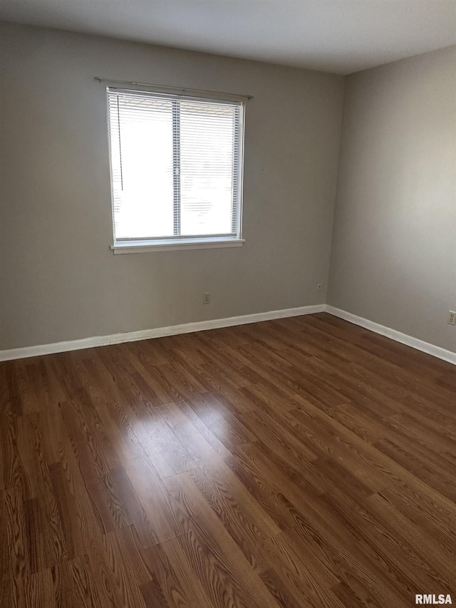 unfurnished room with dark wood-type flooring