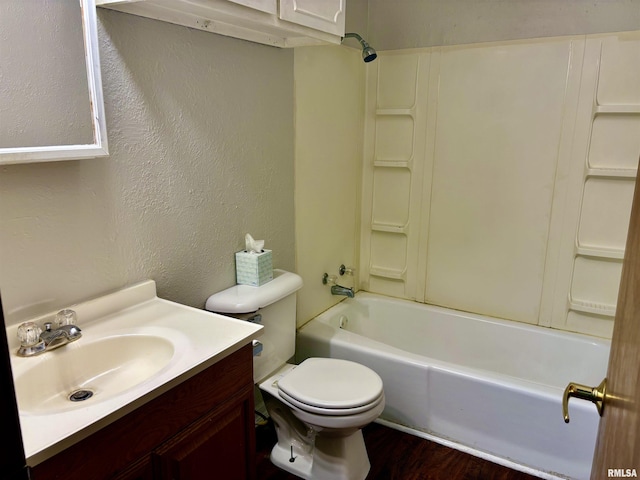 full bath featuring bathtub / shower combination, a textured wall, vanity, and toilet