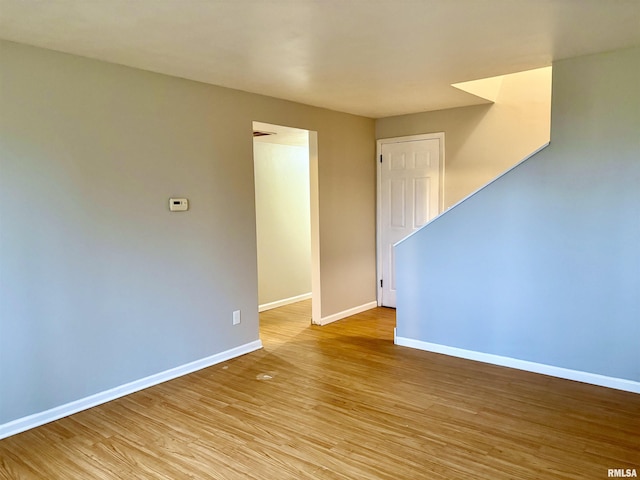 unfurnished room with light wood finished floors and baseboards