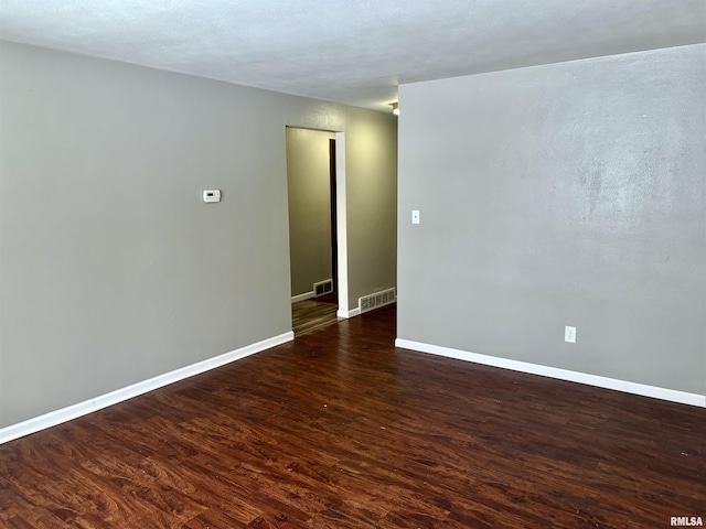 spare room featuring dark hardwood / wood-style flooring