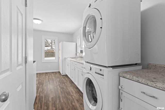 laundry room with cabinets, dark hardwood / wood-style floors, stacked washer and clothes dryer, and sink