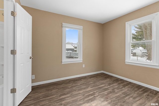 unfurnished room with dark hardwood / wood-style floors and a wealth of natural light