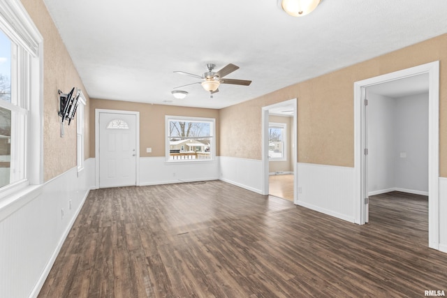 unfurnished living room featuring ceiling fan and dark hardwood / wood-style floors