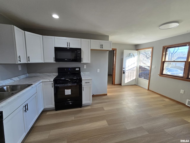 kitchen featuring black appliances and white cabinets