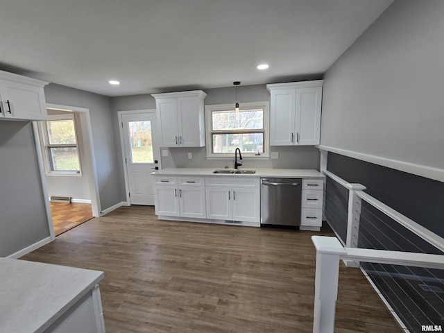 kitchen with white cabinets, decorative light fixtures, stainless steel dishwasher, and sink