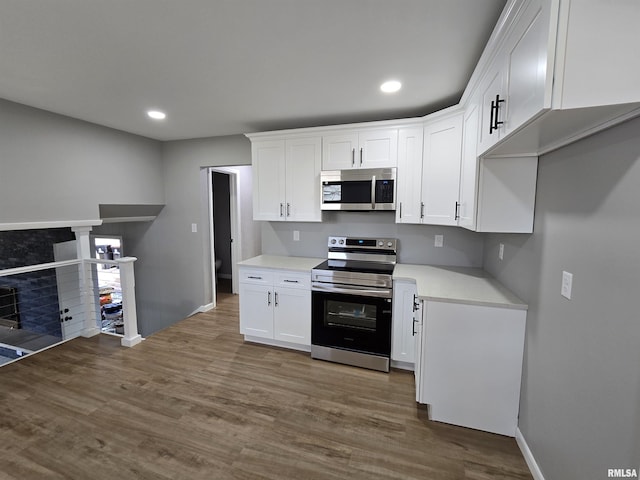 kitchen with hardwood / wood-style flooring, white cabinetry, and stainless steel appliances