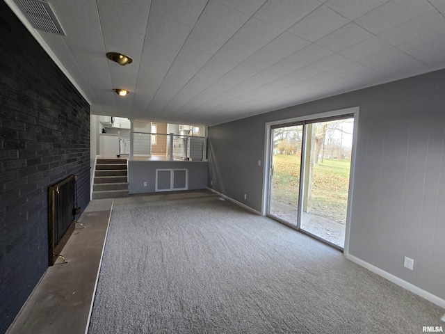 unfurnished living room with dark colored carpet and a fireplace