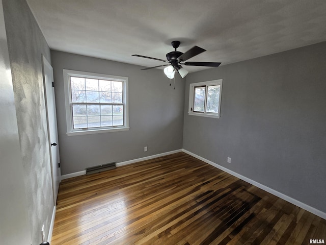 unfurnished room with dark hardwood / wood-style floors, ceiling fan, and a healthy amount of sunlight