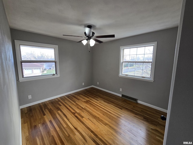 empty room featuring ceiling fan and dark wood-type flooring