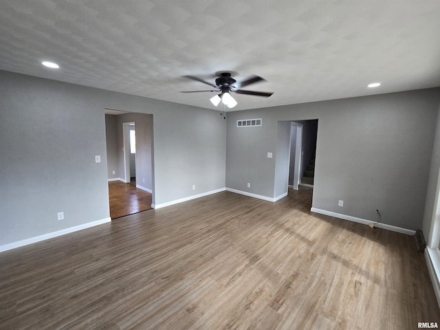 empty room with hardwood / wood-style floors and ceiling fan