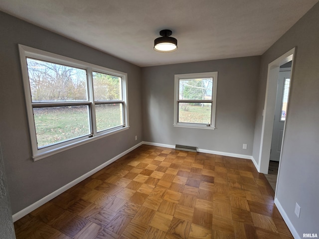 unfurnished room with a baseboard heating unit and parquet flooring