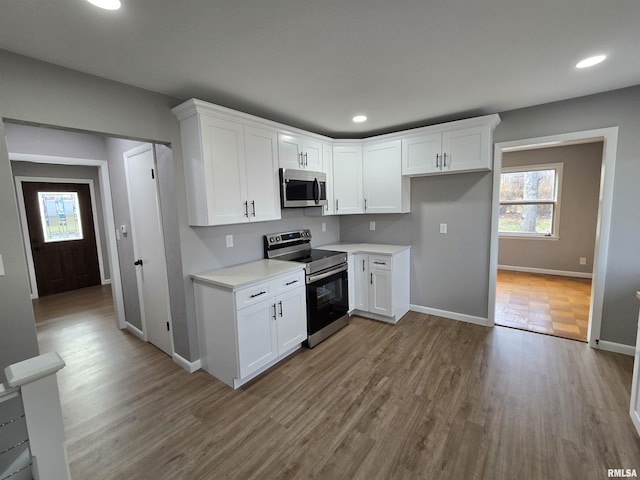 kitchen featuring white cabinets, stainless steel appliances, and light hardwood / wood-style floors