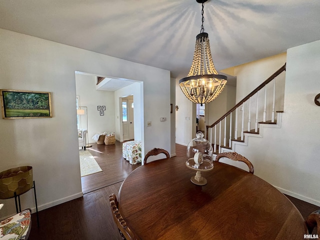 dining area with dark wood-type flooring and a notable chandelier