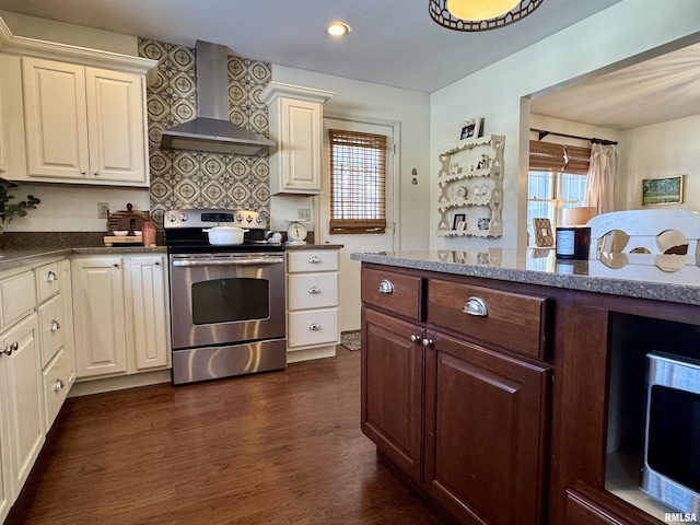 kitchen with backsplash, dark wood-type flooring, dark stone counters, electric stove, and wall chimney range hood