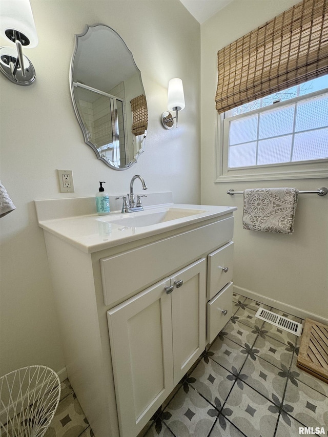 bathroom with tile patterned flooring, vanity, and a shower with shower door