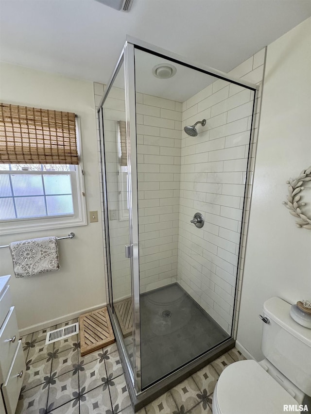 bathroom with tile patterned flooring, vanity, toilet, and a shower with shower door