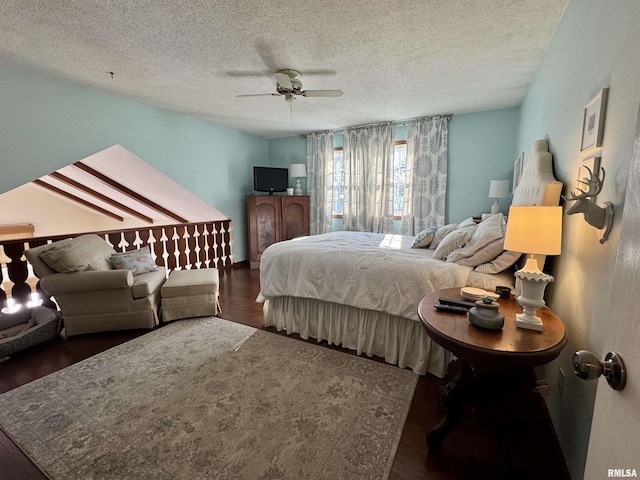 bedroom with a textured ceiling, ceiling fan, and dark wood-type flooring