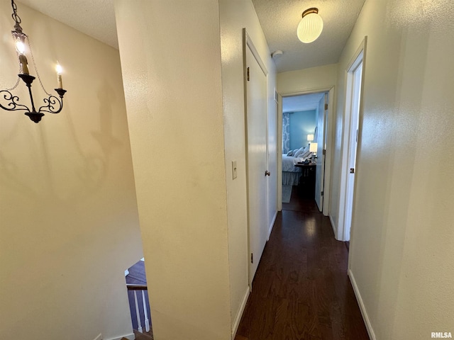 corridor featuring dark hardwood / wood-style floors and a textured ceiling