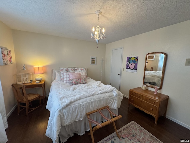 bedroom with a textured ceiling, dark hardwood / wood-style flooring, and an inviting chandelier