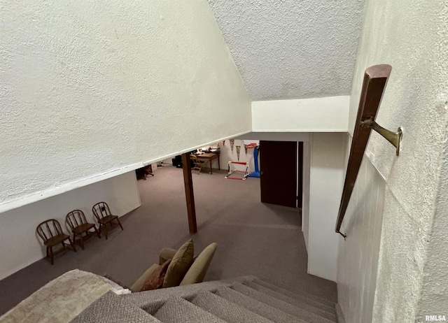 stairway featuring carpet flooring and vaulted ceiling