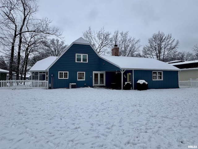 view of snow covered rear of property