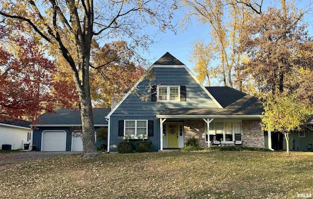 view of front facade featuring a porch, a garage, and a front yard