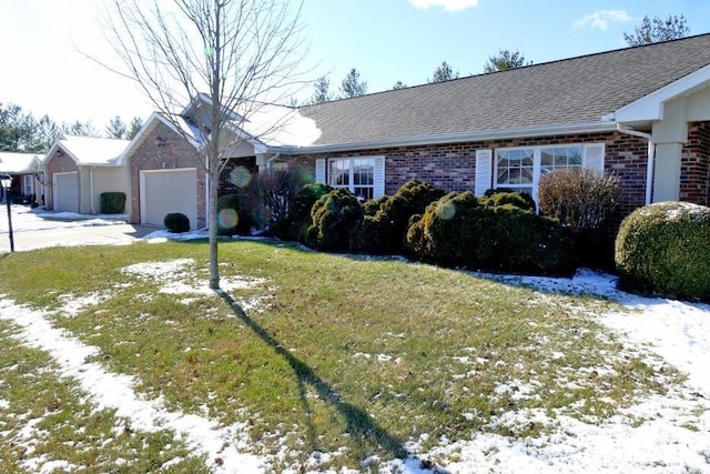 ranch-style home with a garage and a yard