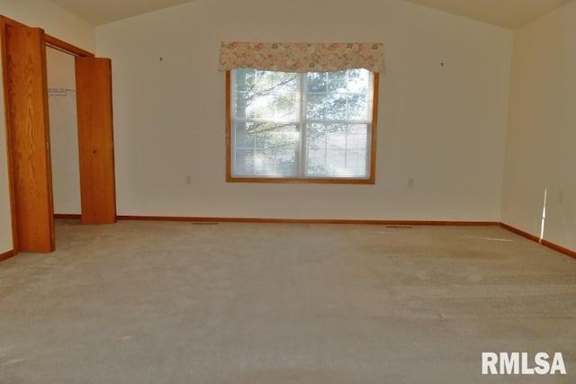 spare room featuring carpet floors and vaulted ceiling