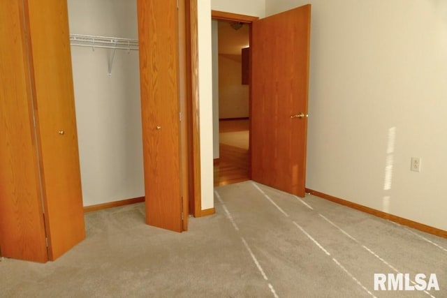 unfurnished bedroom featuring light colored carpet and a closet