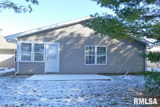 snow covered property with a patio